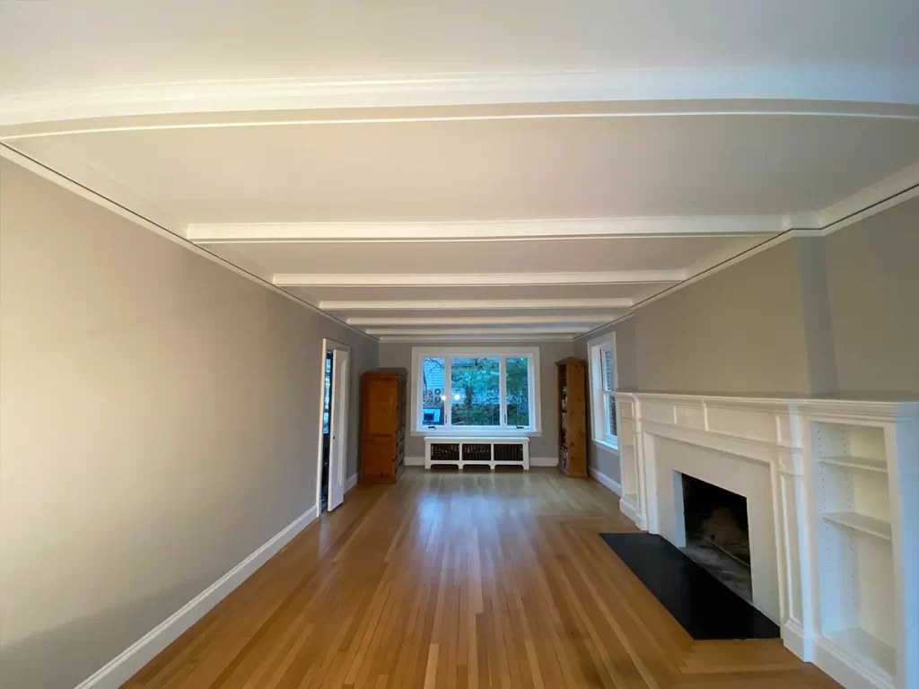A freshly painted living room with hardwood floors and a fireplace