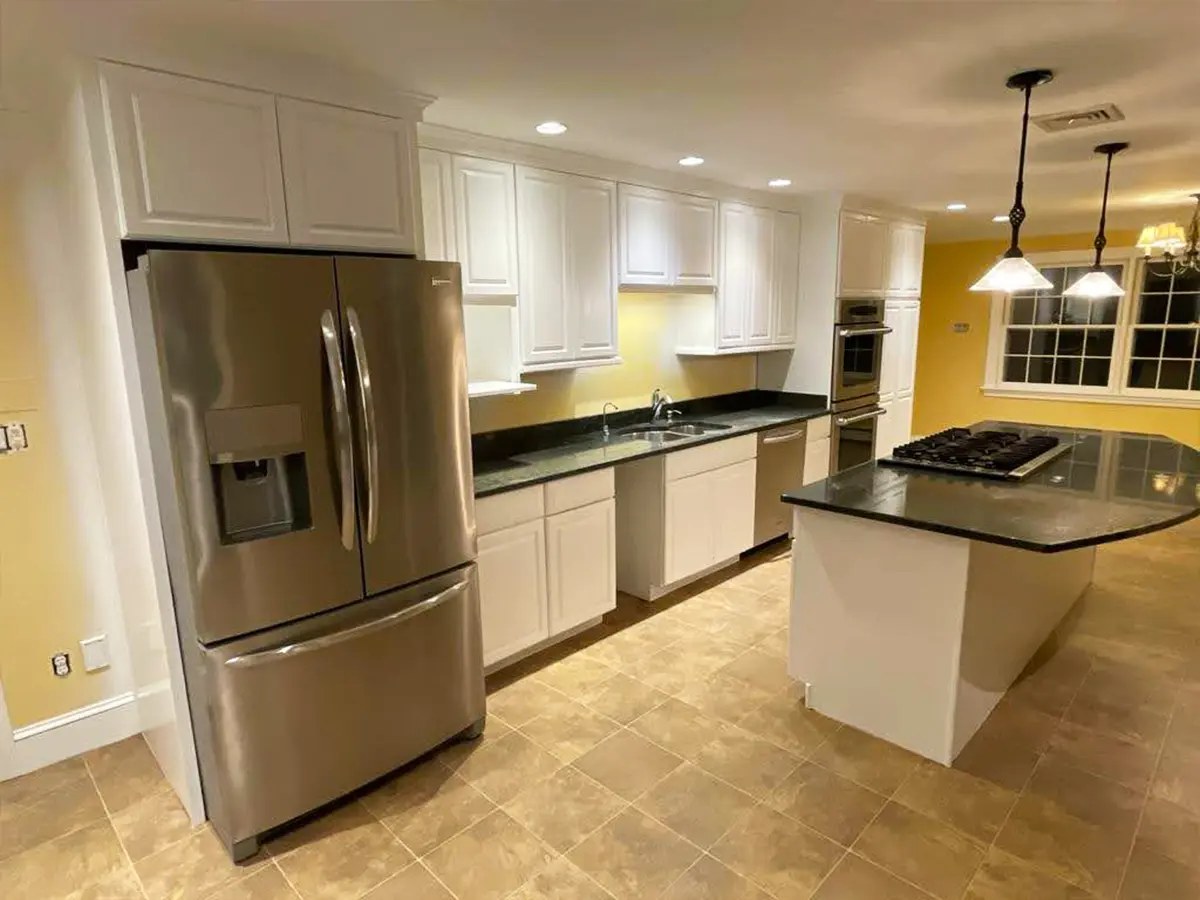 A kitchen with freshly painted white cabinets