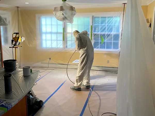 A painter working in a room sealed off and protected for painting