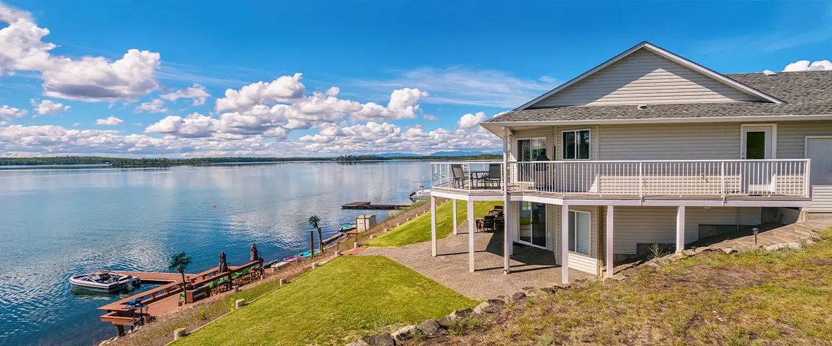 A lakefront home with a spacious deck and white railing