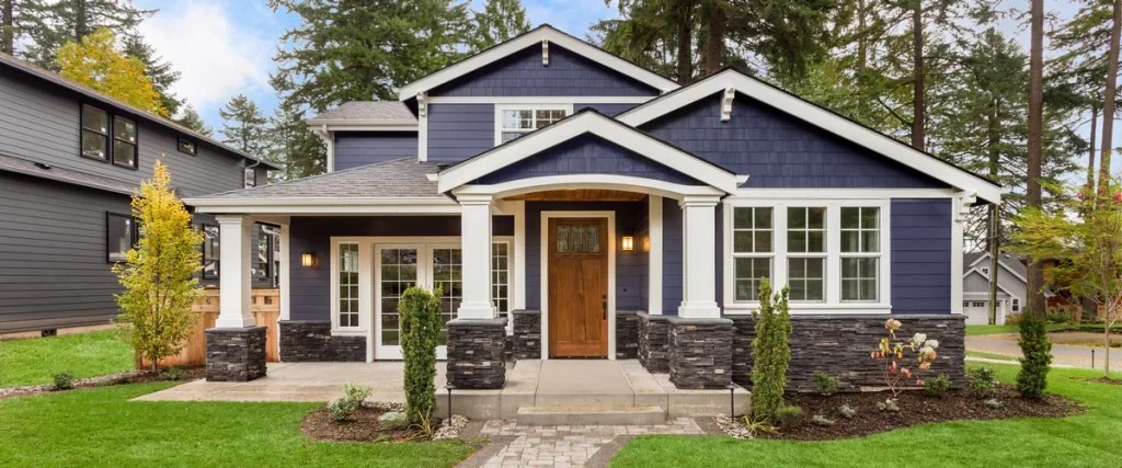 A home exterior painted dark blue with white trim and stone accents